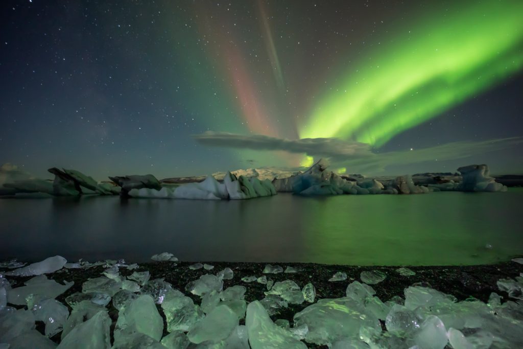 Aurora Boreal em lagoa glacial na Islândia