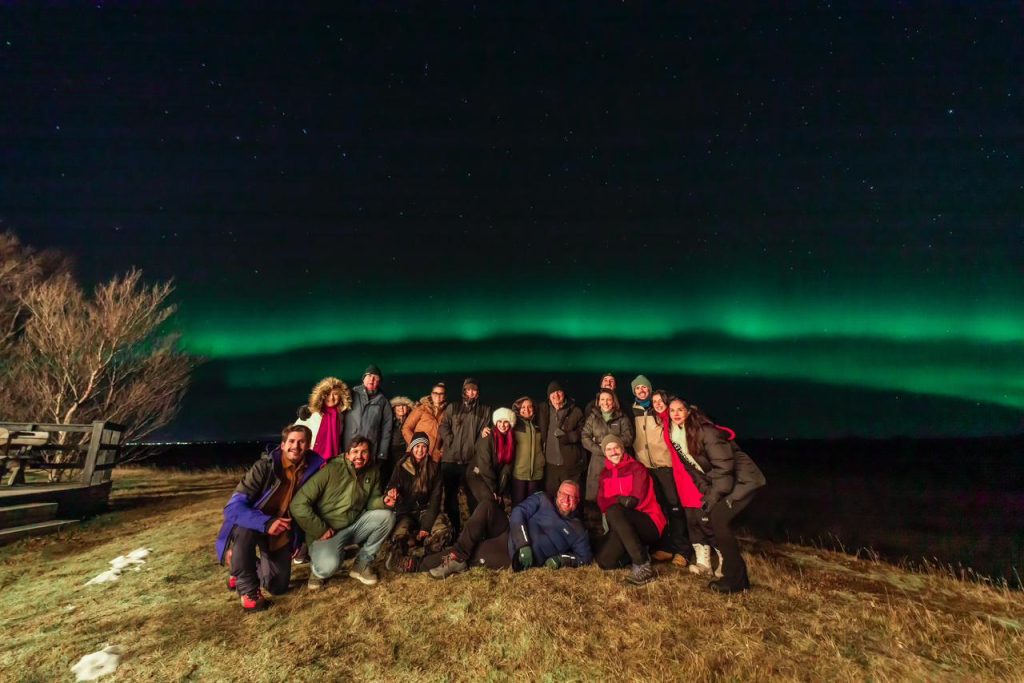 Viajantes da Expedição Islândia® 2025 em noite de Aurora Boreal.