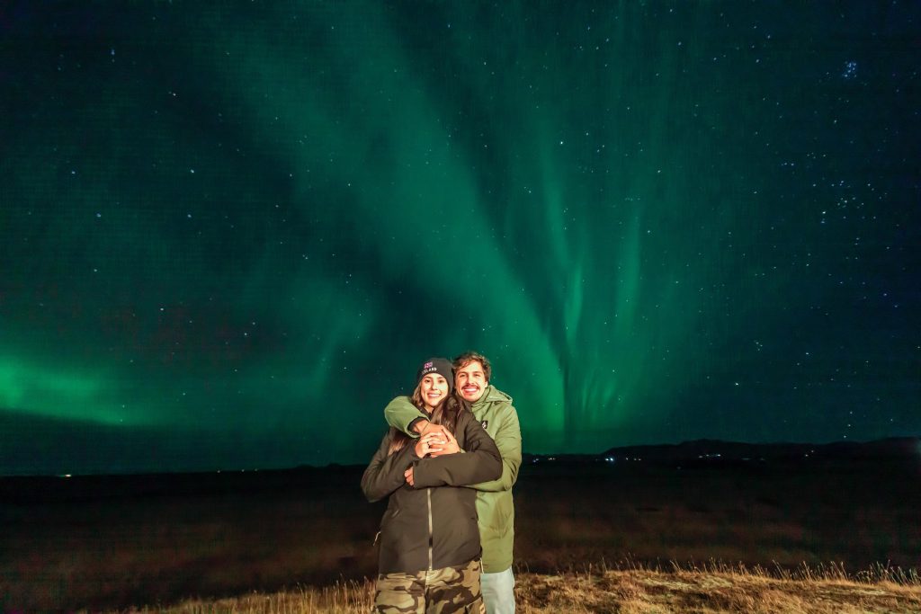 Viajantes da Expedição Islândia® 2025 em noite de Aurora Boreal.