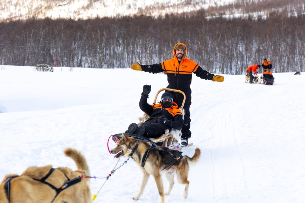 Viajantes da Expedição Ártico durante o passeio de dogsledding.