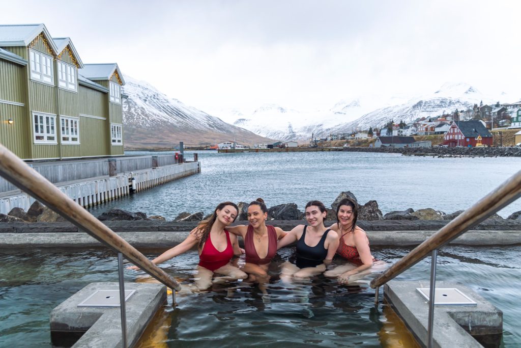 Grupo da Expedição Islândia em uma hot tube com vista para as montanhas nevadas.