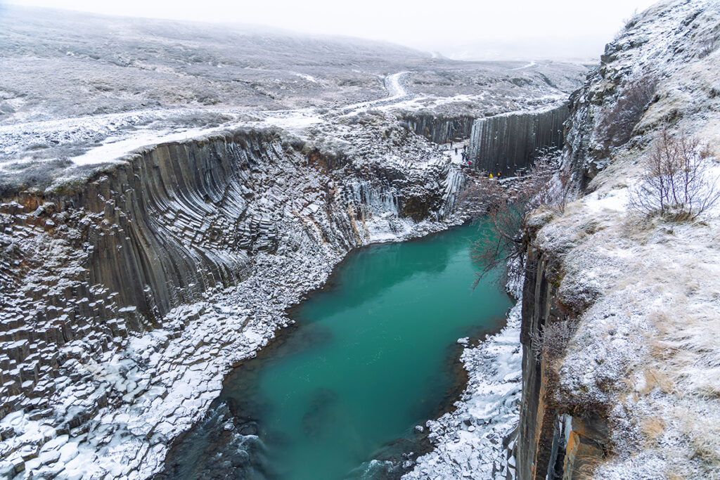 Cânion formado por colunas de basalto e águas azul-esverdeadas. 